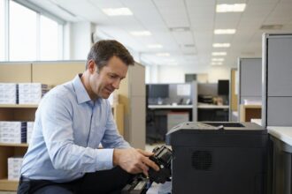 Responsable de bureau installant un toner compatible dans une imprimante laser en entreprise